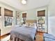 Bright bedroom with two windows, decorative lamps, floral pillows, and a patterned comforter at 2110 E 5Th St, Charlotte, NC 28204