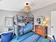 Bedroom featuring a bunk bed, blue rug, dresser, and large window at 2110 E 5Th St, Charlotte, NC 28204