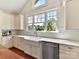 Farmhouse sink and white marble countertops with stainless dishwasher and great natural light at 2110 E 5Th St, Charlotte, NC 28204