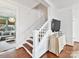 Staircase featuring white railings, wooden steps, and a view into the living room, blending modern design at 2110 E 5Th St, Charlotte, NC 28204