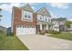 Attractive two-story home showcasing a two-car garage, brick accents, and well-kept lawn at 4233 Poplin Grove Dr, Indian Trail, NC 28079