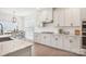 An open-concept kitchen with white cabinets, granite countertops, a view into the dining room, and stainless steel appliances at 4233 Poplin Grove Dr, Indian Trail, NC 28079