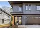 Modern two-story home with dark gray siding, attached garage, and a stylish front entrance at 3623 Avalon Ave, Charlotte, NC 28208