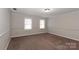 Neutral bedroom with tan carpet, wainscoting, and two windows with natural light at 617 Saint Andrews Rd, Statesville, NC 28625