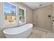 Bright bathroom featuring soaking tub, tile floors, and a large window at 5022 Ohm Ln, Charlotte, NC 28270