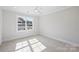 Bright bedroom with a large window showcasing natural light and a ceiling fan at 5022 Ohm Ln, Charlotte, NC 28270