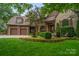 Brick home with three-car garage, fountain, and manicured lawn at 5523 Closeburn Rd, Charlotte, NC 28210