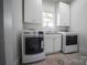 Bright laundry room with white cabinets and modern washer/dryer at 5523 Closeburn Rd, Charlotte, NC 28210