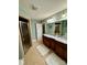 Bathroom with dual sinks, granite counters, decorative floral arrangement, shower, and tiled flooring at 152 Bridge Pointe Ln, Hickory, NC 28601