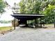 Lakefront property features a metal carport, small shed and gravel driveway at 152 Bridge Pointe Ln, Hickory, NC 28601