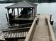 A stunning dock featuring a boat lift with a covered top and a wooden walkway that leads to the lake at 152 Bridge Pointe Ln, Hickory, NC 28601