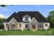 Charming home showcasing stone and white brick, complemented by manicured lawn and beautiful landscaping at 00 Mcfalls Ln # 02, Indian Land, SC 29707