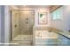 Bathroom featuring a separate glass shower and soaking tub, with neutral tile and modern fixtures at 133 Sari St, Troutman, NC 28166