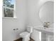 Elegant powder room with pedestal sink, round mirror, and modern fixtures at 3112 Beacon Heights Rd, Indian Land, SC 29707