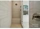 The shower features a built-in bench, neutral stone and tile, and natural light at 3112 Beacon Heights Rd, Indian Land, SC 29707
