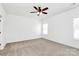 An airy bedroom with neutral carpet, two windows, and a ceiling fan at 4206 Old Monroe Marshville Rd, Wingate, NC 28174