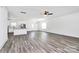 Open-concept living space with wood-look floors, connecting the living room, kitchen, and dining area for seamless living at 4206 Old Monroe Marshville Rd, Wingate, NC 28174