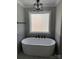 Bright bathroom featuring modern soaker tub with black fixtures under beautiful window at 59 Browning Dr, Taylorsville, NC 28681