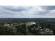 An aerial perspective of a residential neighborhood, with houses surrounded by green trees against a cloudy sky at 113 Fairview St, Clover, SC 29710