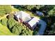 Aerial view of the red brick house with a large roof, well-maintained landscaping, and a long driveway at 102 Sleaford Ct, Dallas, NC 28034