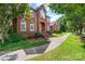 Charming red brick home with arched windows, manicured landscaping, and a inviting walkway to the front door at 102 Sleaford Ct, Dallas, NC 28034