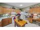 Well-lit kitchen featuring wooden cabinetry, white appliances, and a functional center island at 102 Sleaford Ct, Dallas, NC 28034
