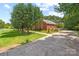 View of side yard showing the brick house, grass and mature trees and long driveway to street at 102 Sleaford Ct, Dallas, NC 28034