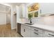 Bright kitchen sink area with a modern faucet, wooden trim window, and stainless steel dishwasher and white countertops at 1025 Baylor Grove Rd, Monroe, NC 28112