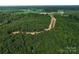 Scenic aerial view of wooded property with a well-constructed access road for future development at 1025 Baylor Grv, Monroe, NC 28112