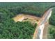 Aerial view of land lot in a new community with mature trees and a pond nearby at 1025 Baylor Grv, Monroe, NC 28112