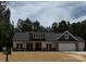 Charming single-Gathering home featuring a two-car garage, stone accents, and a well-manicured lawn at 1025 Baylor Grv, Monroe, NC 28112