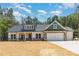 Charming home with stone accents, an attached two car garage and beautiful sky backdrop at 1025 Baylor Grv, Monroe, NC 28112