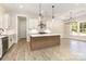 Eat-in kitchen with white cabinets, island with quartz countertop, stainless steel appliances and pendant lighting at 1025 Baylor Grv, Monroe, NC 28112