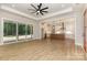 Spacious living room open to kitchen featuring wood floors, large windows, and sliding glass door at 1025 Baylor Grv, Monroe, NC 28112