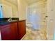 Well-lit bathroom with dual vanity, bathtub, and dark granite counters at 4327 Kobuk Ln, Charlotte, NC 28269