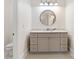 This bathroom offers a round mirror and vanity with a light gray cabinet at 5916 Bridger Ct, Charlotte, NC 28211