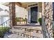 Welcoming front porch with stone steps, a cozy bench with green pillows, and elegant black door at 5916 Bridger Ct, Charlotte, NC 28211