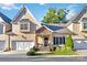 Charming townhome with a stone-accented entryway, white garage doors, and well-maintained landscaping at 5916 Bridger Ct, Charlotte, NC 28211