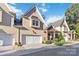 View of the townhome featuring a two-car garage, stone entryway, and manicured landscaping at 5916 Bridger Ct, Charlotte, NC 28211
