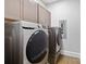 A laundry room features front-loading appliances and a set of cabinets at 5916 Bridger Ct, Charlotte, NC 28211