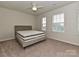 Bedroom with neutral carpet, ceiling fan, and windows providing natural light, complemented by a comfortable-looking mattress at 16725 Cozy Cove Rd, Charlotte, NC 28278