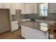 Modern kitchen with white cabinets, granite island, and herringbone backsplash at 318 Lewis Ferry Rd, Statesville, NC 28677