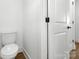 Bright bathroom featuring a toilet and a classic white door at 3000 Celia Ave, Charlotte, NC 28216