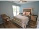 Cozy bedroom with wood-look flooring, neutral colors, and a large window with blinds at 18867 Vineyard Point Ln, Cornelius, NC 28031
