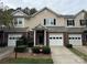 Tan brick townhouse with a two-car garage and landscaping at 5346 Johnston Mill Ct, Charlotte, NC 28269