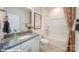 Well-lit bathroom featuring granite countertops, a single sink vanity, framed mirror, and a shower-tub combination at 121 Sari St, Troutman, NC 28166