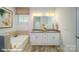 Bright bathroom with a double vanity, white cabinets and separate tub at 121 Sari St, Troutman, NC 28166