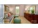 Bright, stylish bedroom with a daybed, decorative pillows, a wooden dresser, and two soft green poufs at 121 Sari St, Troutman, NC 28166