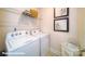 Functional laundry room with a side-by-side washer and dryer, wire shelving, and decorative wall art at 121 Sari St, Troutman, NC 28166