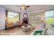 Cozy living room with comfortable seating, a ceiling fan, a fireplace, and natural light from two windows at 121 Sari St, Troutman, NC 28166